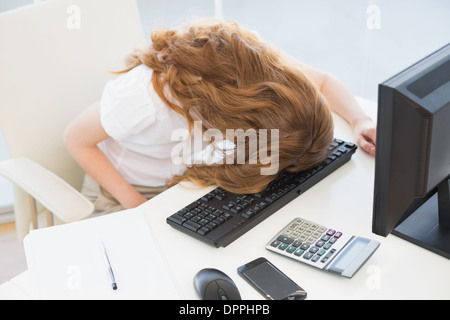 Geschäftsfrau ruhen Kopf auf die Tastatur im Büro Stockfoto