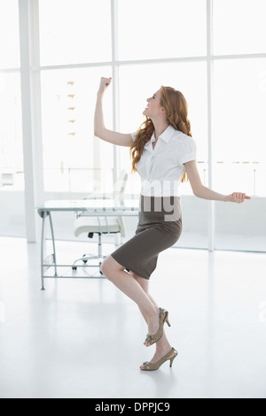 Fröhliche elegante Geschäftsfrau im Büro jubelt Stockfoto