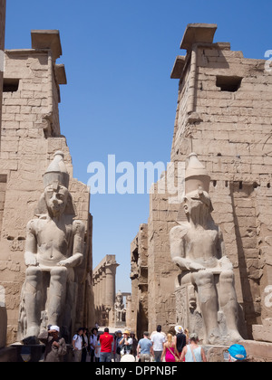 Zwei sitzende Statuen von Ramses II bewachen den großen Pylon, der Tempel von Luxor, Ägypten Stockfoto