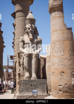 Einer der zwei sitzende Statuen von Ramses II bewachen den großen Pylon, der Tempel von Luxor, Ägypten Stockfoto