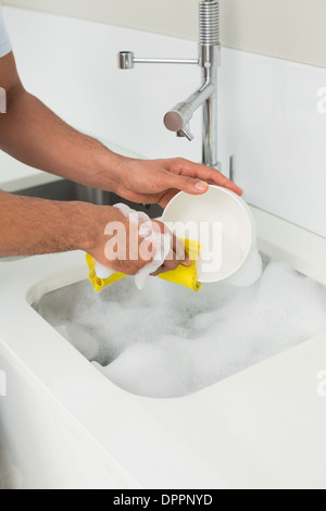 Hände, die das Geschirr im Spülbecken Stockfoto