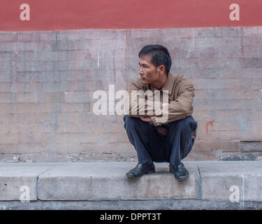 Peking, China. 26. Oktober 2006. In einer hockenden Pose in China üblich ruht ein Mann auf einem Gehweg in Peking, Hauptstadt der Republik China. © Arnold Drapkin/ZUMAPRESS.com/Alamy Live-Nachrichten Stockfoto