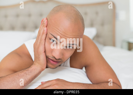 Glatze Mann leidet unter Zahnschmerzen im Bett Stockfoto