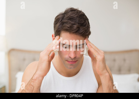 Nahaufnahme von einem Mann leidet unter Kopfschmerzen im Bett Stockfoto