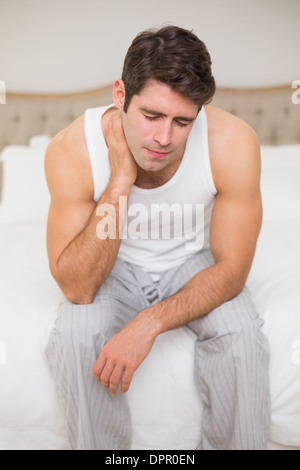 Junge Mann leidet unter Nacken Schmerzen im Bett Stockfoto