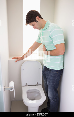 Mann mit Magen Übelkeit Erbrechen in die Toilette Stockfoto