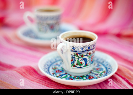 Zwei Tassen Kaffee Türkisch auf einem lila gestreiften Schal-Hintergrund Stockfoto