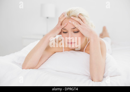 Gespannten hübsche Frau im Bett liegend Stockfoto