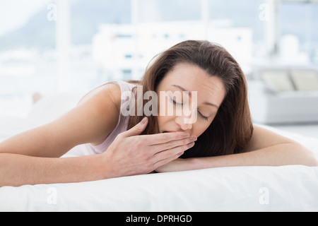 Frau mit geschlossenen Augen in Bett Gähnen Stockfoto