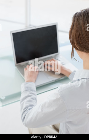 Rückansicht der Geschäftsfrau mit Laptop im Büro Nahaufnahme Stockfoto