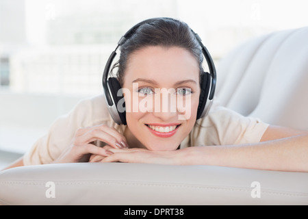 Entspannte casual junge Frau Musikgenuß auf sofa Stockfoto