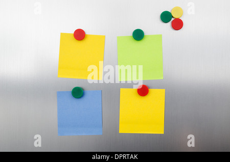 Farbige Notizen und Magnete auf Inox metallic Kühlschrank Stockfoto