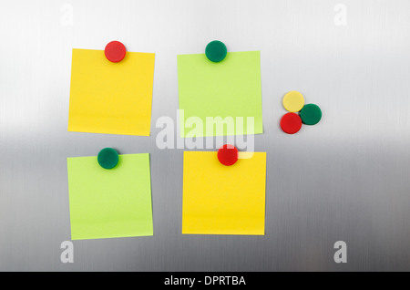 Farbige Notizen und Magnete auf Inox metallic Kühlschrank Stockfoto