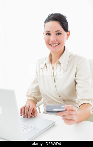 Porträt von eine lächelnde junge Geschäftsfrau machen Online-shopping Stockfoto