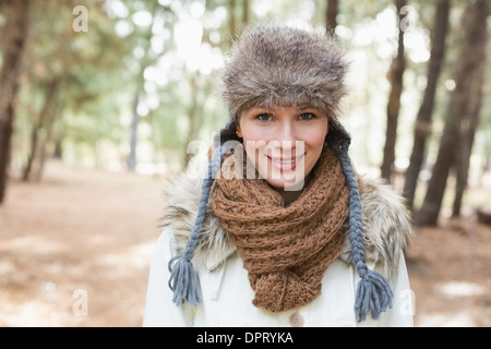 Frau trägt Pelzhut mit Schal und Jacke in Wäldern Stockfoto