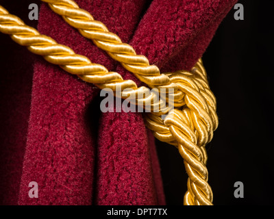 Roter Samtvorhang mit Quaste. Knoten im Seil hautnah Stockfoto