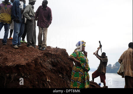 1. April 2009 - Uhren Bukavu, dem Republik Kongo - eine unbekannte Frau wie ein Mann auf der Erde in der Nähe von Bukavu, demokratische Republik Kongo gräbt. Der Kongo ist ein riesiges Land ständig im Krieg, blutigen Konflikte in der Regel initiiert oder verstärkt durch den weniger wohlhabenden Nachbarn.  Das zentralafrikanische Land ist unfassbar reich mit Edelsteinen und natürlichen Ressourcen-- aber ohne Frieden, die Cong Stockfoto