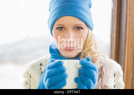 Nette Frau mit Kaffeetasse in warme Kleidung Stockfoto