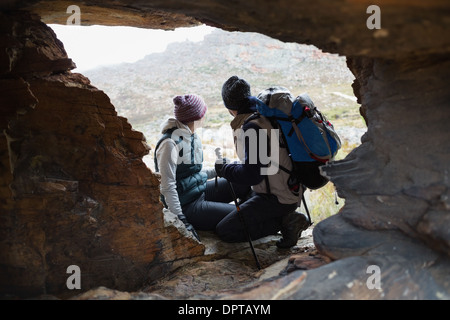 Paar durch Felsenhöhle während auf einer Wanderung gesehen Stockfoto