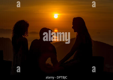 Rio De Janeiro, Brasilien. 16. Januar 2014. Touristen sind Silhouette, wie sie den Sonnenaufgang in der Nähe der Guanabara-Bucht in Rio De Janeiro, Brasilien, 16. Januar 2014 zu beobachten. Bildnachweis: Xu Zijian/Xinhua/Alamy Live-Nachrichten Stockfoto