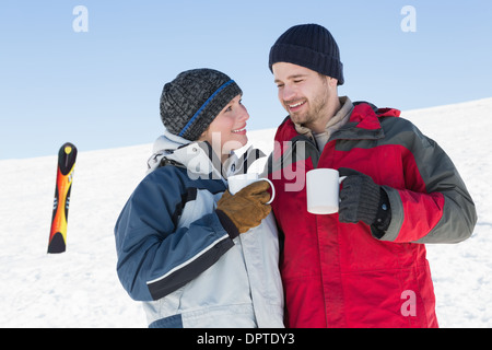 Liebespaar Kaffeetrinken mit Ski Board im Schnee Stockfoto