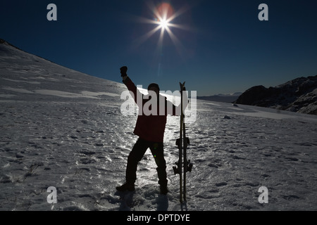 Silhouette Mann hob die Hand mit Ski Board auf Schnee Stockfoto