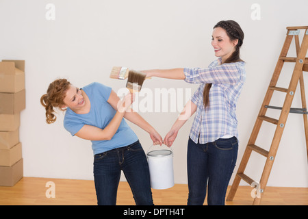 Freunde mit Pinsel und können in einem neuen Haus Stockfoto