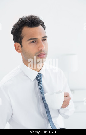 Ernst gut gekleideter Mann Kaffee trinken Stockfoto
