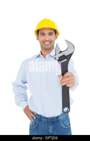 Lächelnde junge Handwerker hielt einen Schraubenschlüssel Stockfoto