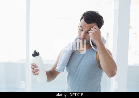 Man wischt Schweiß mit Handtuch im Fitness-studio Stockfoto