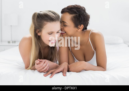 Zwei glückliche junge Freundinnen im Bett Stockfoto