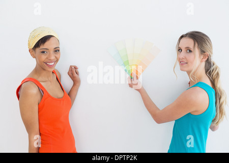 Freundinnen, die Wahl der Farbe für einen Raum zu malen Stockfoto