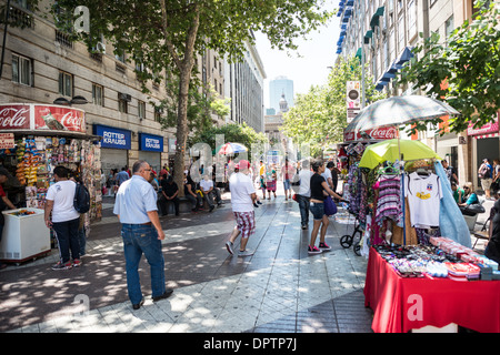 SANTIAGO, Chile – Eine lebhafte Fußgängerzone in der Nähe der historischen Plaza de Armas pulsiert mit Leben im Herzen von Santiago de Chile. Diese belebte Straße, gesäumt von einer Mischung aus kolonialer und moderner Architektur, zeigt die dynamische Mischung aus Geschichte und zeitgenössischer urbaner Kultur, die Chiles Hauptstadt definiert. Stockfoto