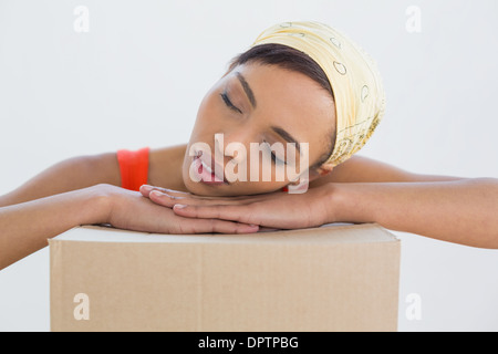 Hübsche junge Frau ruhen Kopf über Boxen Stockfoto