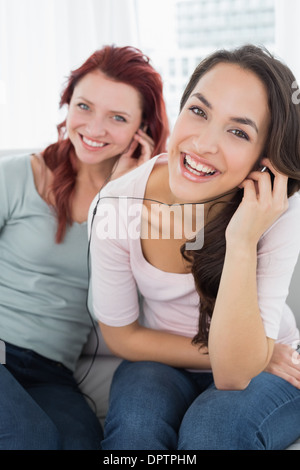 Fröhlichen Freunden zusammen Musik über Kopfhörer hören Stockfoto