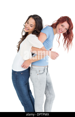 Junge Frauen stehen Rücken an Rücken mit Interlock Händen Stockfoto