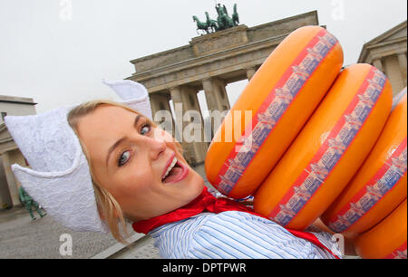 Berlin, Deutschland. 16. Januar 2014. Käse-Jungfrau Stock trägt Stapel von Rädern Gouda-Käse neben dem Brandenburger Tor auf dem Weg zur Grünen Woche in Berlin, Deutschland, 16. Januar 2014. Internationale Grüne Woche findet vom 17. bis 26. Januar 2014 in Berlin. Foto: WOLFGANG KUMM/Dpa/Alamy Live News Stockfoto