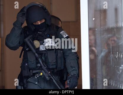 Frankfurt Main, Deutschland. 16. Januar 2014. Sondereinheiten der Polizei (SEK) verlassen ein Mehrfamilienhauses in Frankfurt Main, Deutschland, 16. Januar 2014. Ein 33 Jahre alter Mann verbarrikadiert sich in dem Gebäude mit einer Frau. Der Mann wurde verhaftet. Foto: BORIS ROESSLER/Dpa/Alamy Live News Stockfoto