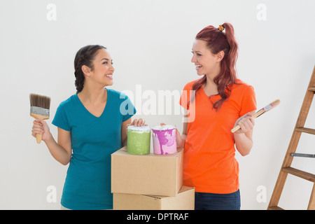 Freunde mit Pinsel, Dosen und Schachteln in einem neuen Haus Stockfoto