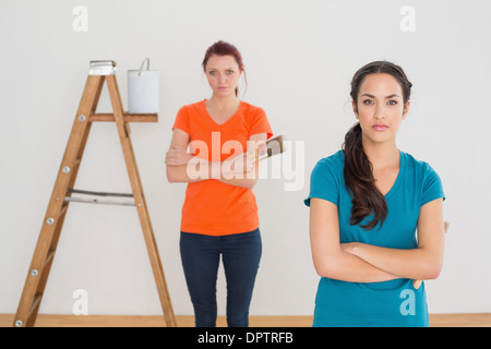 Freunde mit Pinsel und Leiter in einem neuen Haus Stockfoto