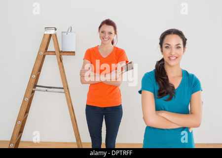 Freunde mit Pinsel und Leiter in einem neuen Haus Stockfoto