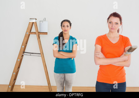 Freunde mit Pinsel und Leiter in einem neuen Haus Stockfoto