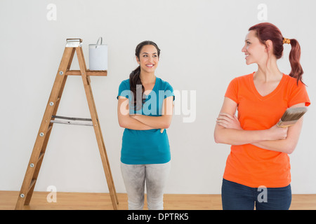 Freunde mit Pinsel und Leiter in einem neuen Haus Stockfoto