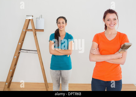 Freunde mit Pinsel und Leiter in einem neuen Haus Stockfoto