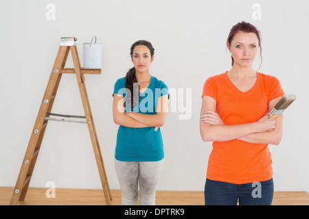 Freunde mit Pinsel und Leiter in einem neuen Haus Stockfoto