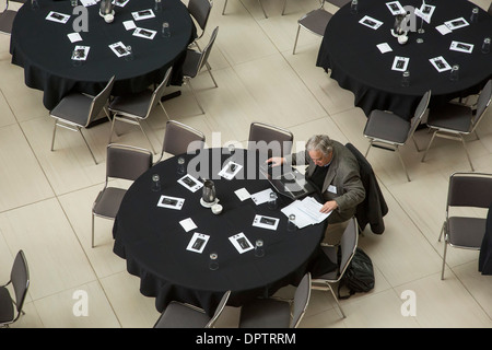 Man arbeitet auf Laptop vor einem Treffen der Society of Automotive Analysis während der North American International Auto Show. Stockfoto
