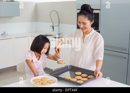 Mädchen helfen ihrer Mutter bereiten Sie Cookies in Küche Stockfoto