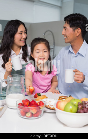 Porträt eines jungen Mädchens, das Frühstück mit den Eltern Stockfoto