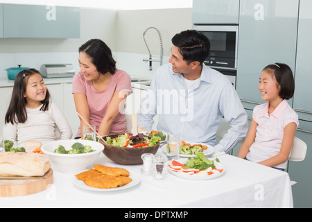 Vierköpfige Familie genießen Sie gesunde Mahlzeit in Küche Stockfoto