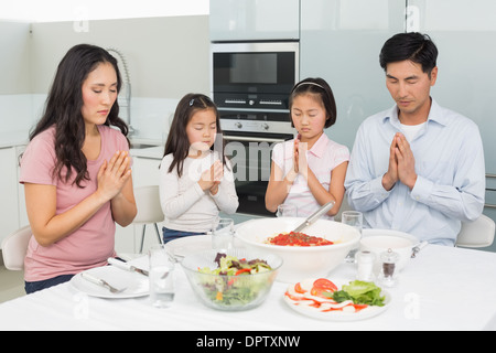 Vierköpfige Familie sagen Gnade vor Mahlzeit in der Küche Stockfoto